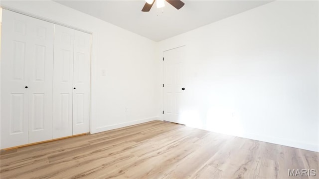 unfurnished bedroom with light wood-style floors, baseboards, a closet, and ceiling fan