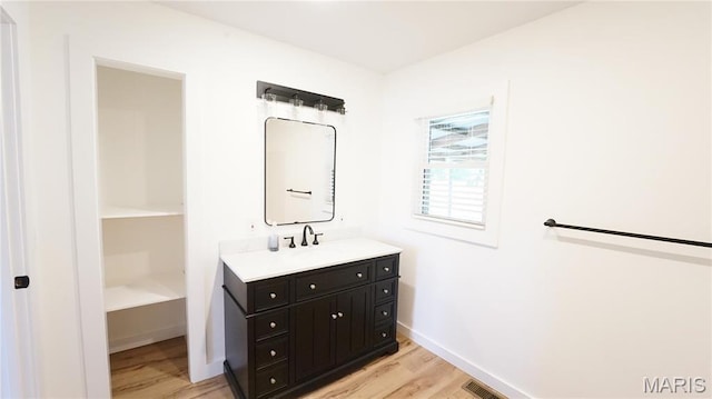 bathroom featuring wood finished floors, baseboards, and vanity