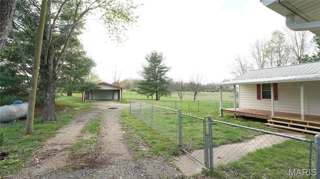 view of yard with an outbuilding, driveway, a gate, and a garage