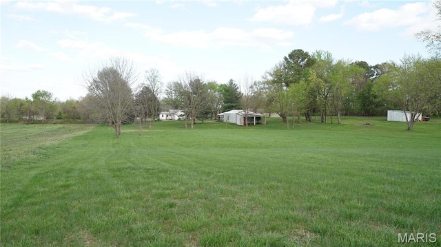 view of green lawn with an outdoor structure