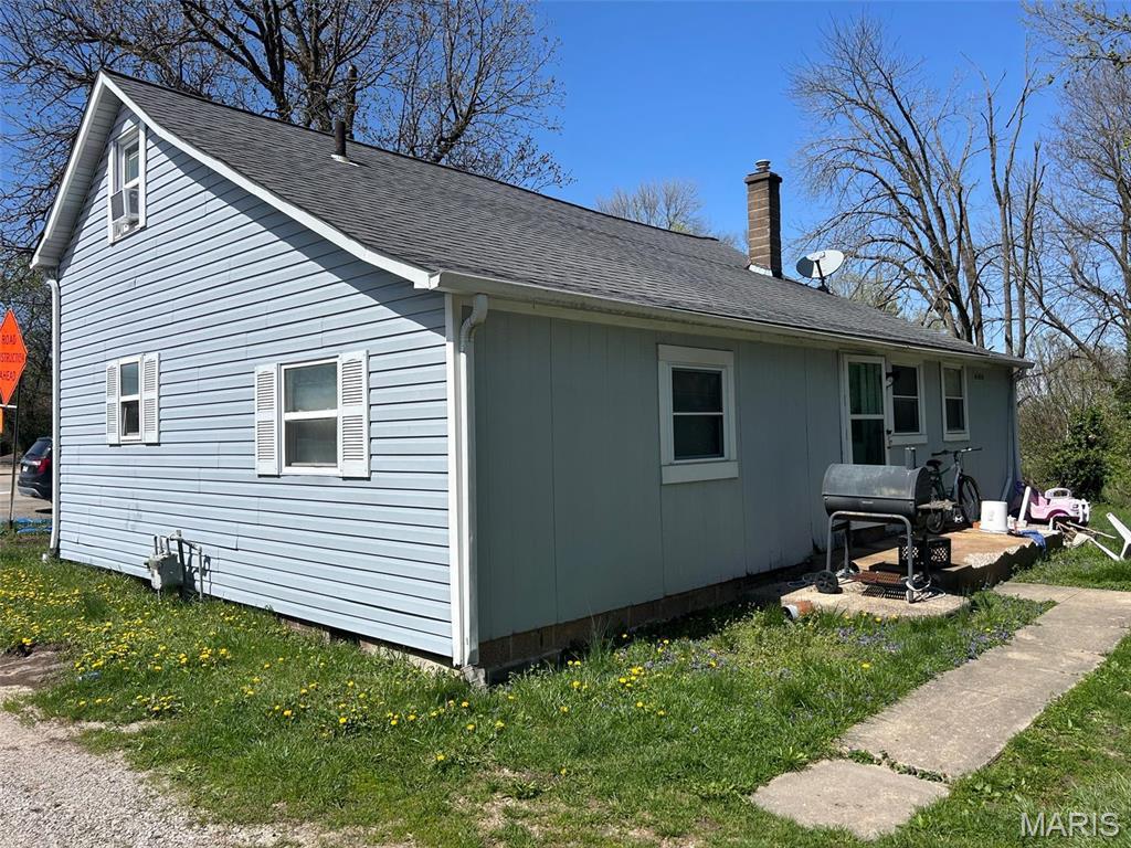 106 N Main St, Shiloh, IL 62269 - view of property exterior featuring a chimney, roof with shingles, and a yard