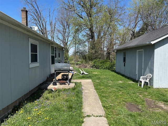 view of green lawn with an outbuilding