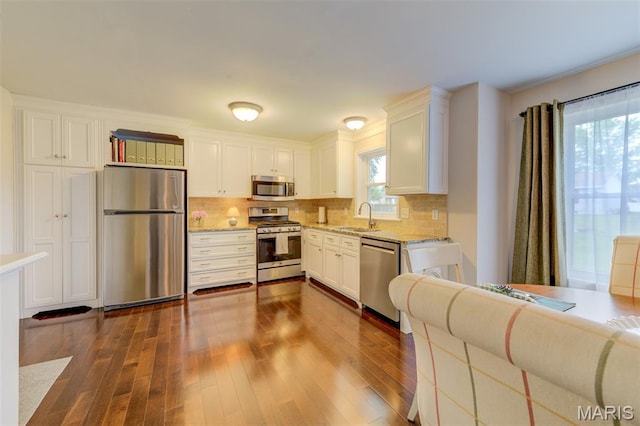 5 W Sunny Hill Blvd, Saint Peters, MO 63376 - kitchen featuring appliances with stainless steel finishes, a sink, dark wood finished floors, white cabinetry, and tasteful backsplash