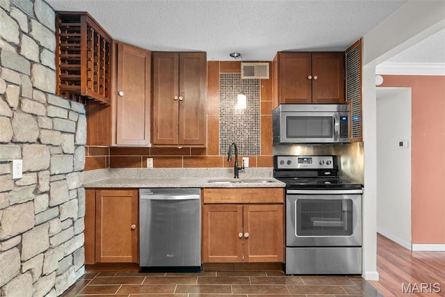 2793 Blackforest Dr Unit B, Saint Louis, MO 63129 - kitchen featuring appliances with stainless steel finishes, a sink, dark wood-type flooring, ornamental molding, and brown cabinets
