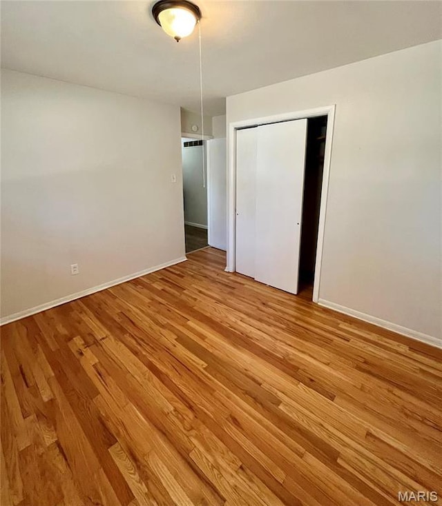 11606 Herefordshire Dr, Saint Louis, MO 63138 - unfurnished bedroom with light wood-style floors, a closet, and baseboards