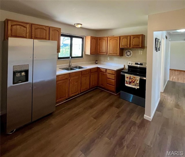 11606 Herefordshire Dr, Saint Louis, MO 63138 - kitchen with stainless steel appliances, a sink, dark wood-style flooring, light countertops, and brown cabinetry