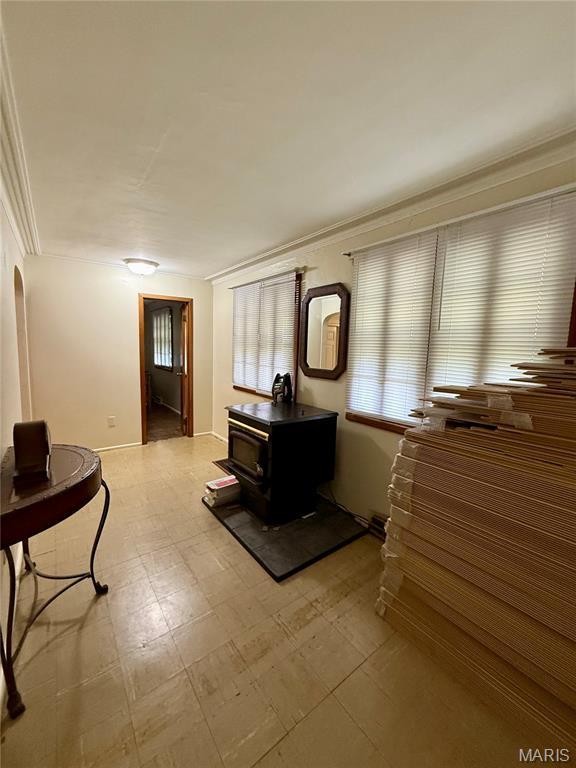 6542 Cedar Hill Rd, Cedar Hill, MO 63016 - living area with a wood stove, ornamental molding, light flooring, and baseboards