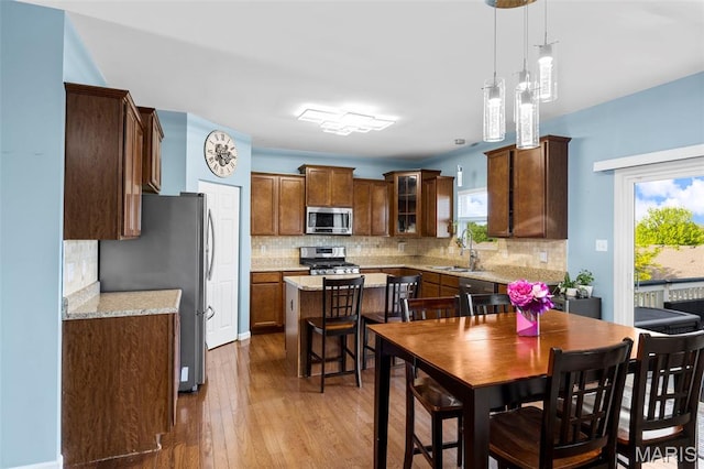77 Brighton Park Dr, Saint Charles, MO 63303 - kitchen featuring appliances with stainless steel finishes, a sink, wood-type flooring, a kitchen island, and tasteful backsplash