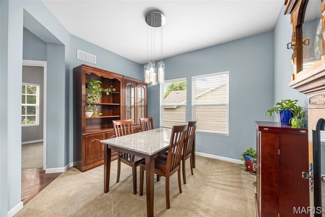 77 Brighton Park Dr, Saint Charles, MO 63303 - dining area with light carpet, a chandelier, and baseboards