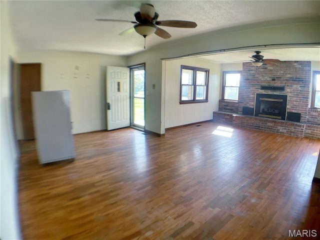 708 Locust St, Edgar Springs, MO 65462 - unfurnished living room with a ceiling fan, wood finished floors, a fireplace, and baseboards