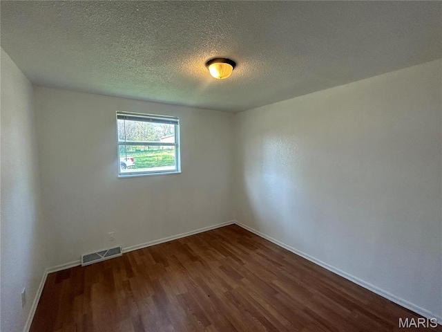 605 Foley, Poplar Bluff, MO 63901 - empty room featuring dark wood-style flooring, baseboards, and a textured ceiling