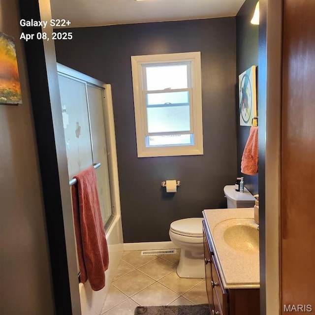 2011 Cypress St, Highland, IL 62249 - bathroom featuring tile patterned floors, vanity, toilet, baseboards, and bath / shower combo with glass door