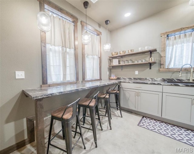 15227 County Road 1110, St James, MO 65559 - kitchen featuring a sink, stone counters, pendant lighting, and a breakfast bar