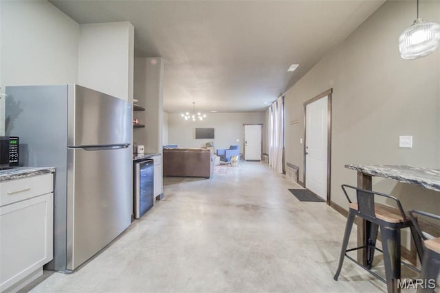 15227 County Road 1110, St James, MO 65559 - kitchen with freestanding refrigerator, finished concrete flooring, white cabinetry, a chandelier, and wine cooler