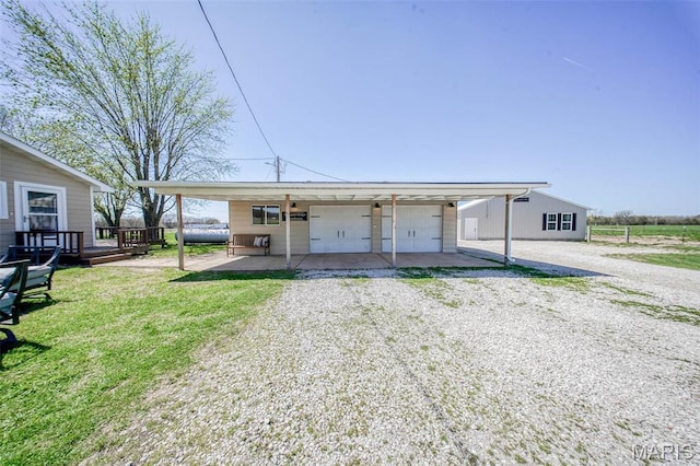 15227 County Road 1110, St James, MO 65559 - view of front of home featuring a detached garage, a front lawn, a deck, and an outbuilding