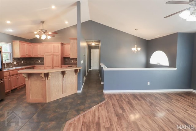 23332 Righteous Ln, Waynesville, MO 65583 - kitchen with a ceiling fan, vaulted ceiling, a breakfast bar area, light brown cabinetry, and tasteful backsplash