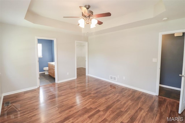 23332 Righteous Ln, Waynesville, MO 65583 - unfurnished bedroom with a tray ceiling, a spacious closet, wood finished floors, and ensuite bathroom
