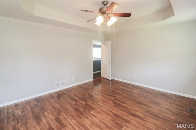 23332 Righteous Ln, Waynesville, MO 65583 - empty room featuring a tray ceiling, a ceiling fan, and wood finished floors