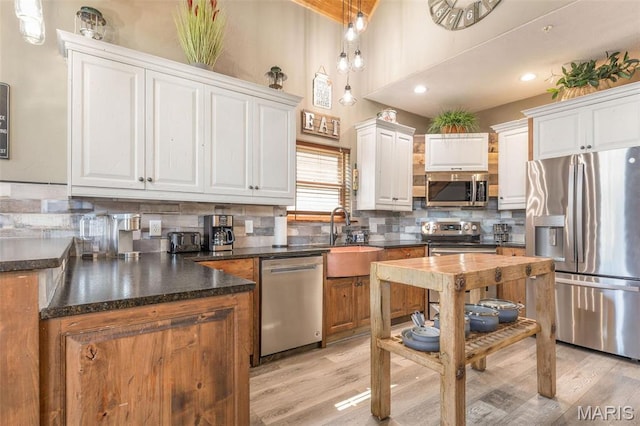 1318 Stormy Point Rd Unit 7, Branson, MO 65616 - kitchen featuring stainless steel appliances, a sink, white cabinets, light wood-style floors, and a towering ceiling