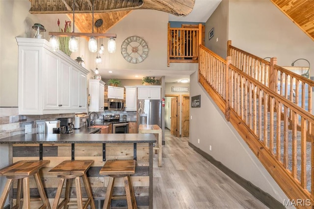 1318 Stormy Point Rd Unit 7, Branson, MO 65616 - kitchen with appliances with stainless steel finishes, wooden ceiling, high vaulted ceiling, a peninsula, and dark countertops