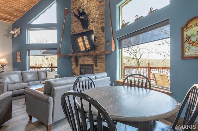 1318 Stormy Point Rd Unit 7, Branson, MO 65616 - dining area with a fireplace, plenty of natural light, wood finished floors, wood ceiling, and high vaulted ceiling