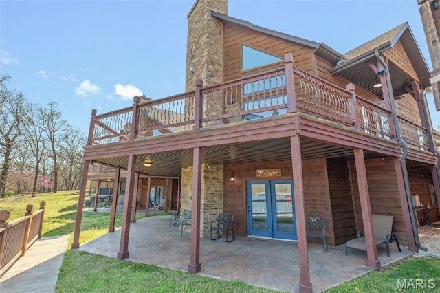 1318 Stormy Point Rd Unit 7, Branson, MO 65616 - rear view of house featuring a deck, a lawn, a chimney, and a patio area