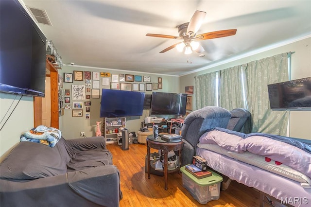 living room with a ceiling fan, wood finished floors, and ornamental molding
