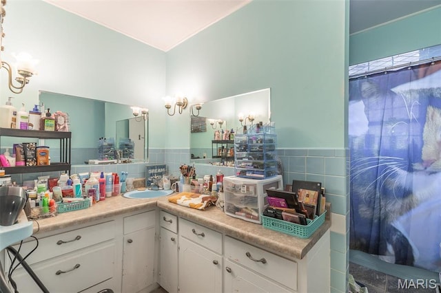 full bathroom featuring tile walls, vanity, a wainscoted wall, a chandelier, and a shower with curtain