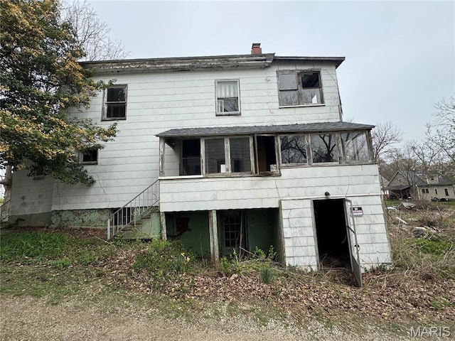 139 N Broad St, Hillsboro, IL 62049 - rear view of house with a sunroom, stairway, and a chimney