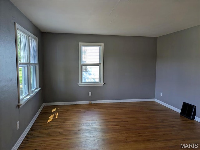 330 N Floridale Ave, Saint Louis, MO 63135 - empty room featuring healthy amount of natural light, wood finished floors, and baseboards