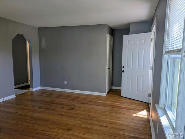 330 N Floridale Ave, Saint Louis, MO 63135 - unfurnished room featuring plenty of natural light, wood finished floors, and arched walkways