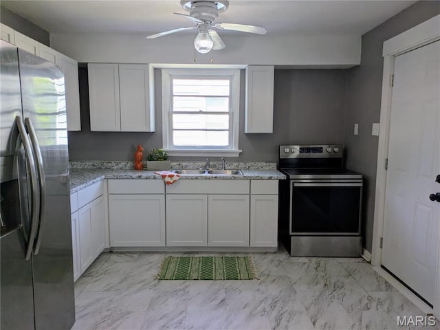 330 N Floridale Ave, Saint Louis, MO 63135 - kitchen featuring stainless steel appliances, a sink, light marble finish floors, ceiling fan, and white cabinets