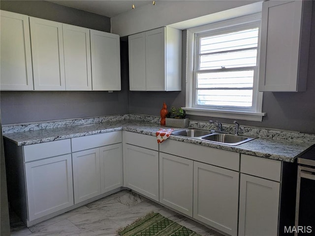 330 N Floridale Ave, Saint Louis, MO 63135 - kitchen featuring a sink, light marble finish flooring, white cabinetry, and light countertops