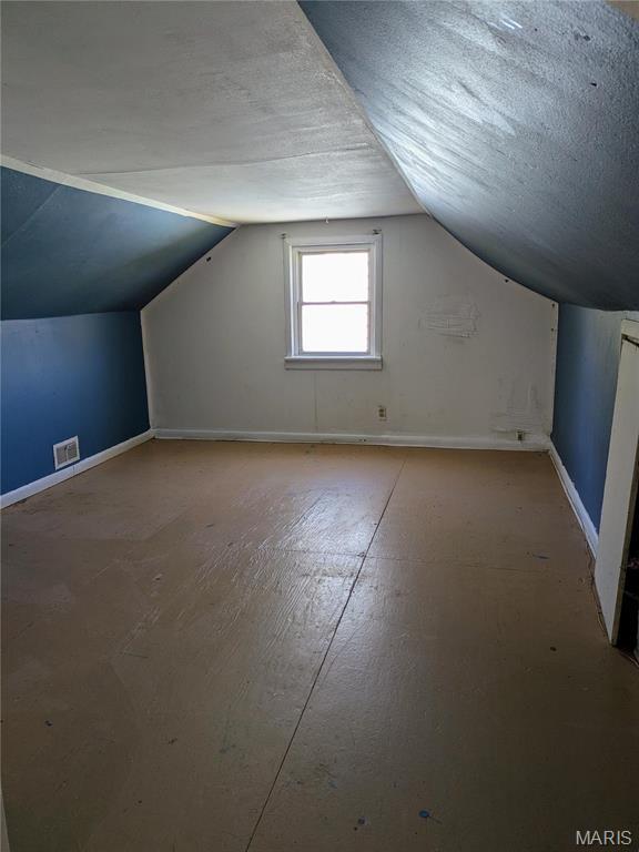 330 N Floridale Ave, Saint Louis, MO 63135 - additional living space with vaulted ceiling, a textured ceiling, and baseboards