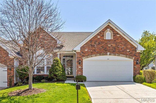 104 Eagle Cove Pl Unit 39B, Saint Charles, MO 63303 - traditional home with a front yard, driveway, brick siding, a garage, and roof with shingles