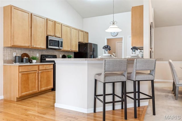 104 Eagle Cove Pl Unit 39B, Saint Charles, MO 63303 - kitchen featuring stainless steel microwave, black fridge with ice dispenser, a kitchen breakfast bar, backsplash, and decorative light fixtures
