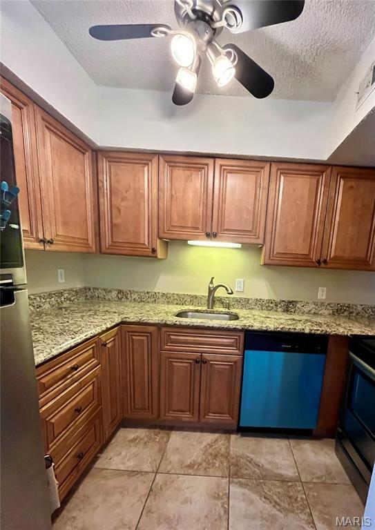 1504 Swallow Dr, Saint Louis, MO 63144 - kitchen featuring dishwasher, a sink, a textured ceiling, ceiling fan, and brown cabinetry