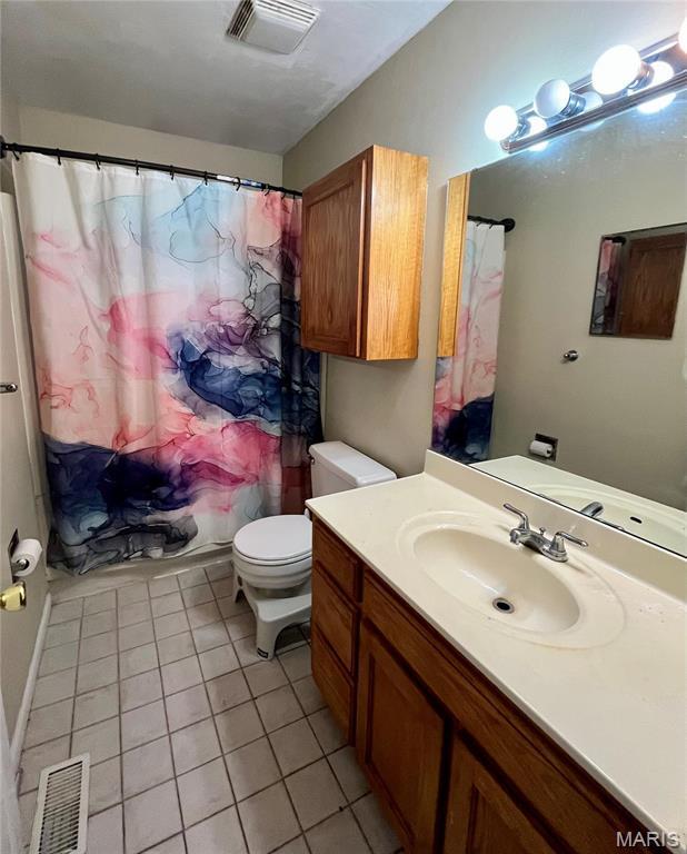 1504 Swallow Dr, Saint Louis, MO 63144 - bathroom with tile patterned flooring, toilet, vanity, and a shower with curtain