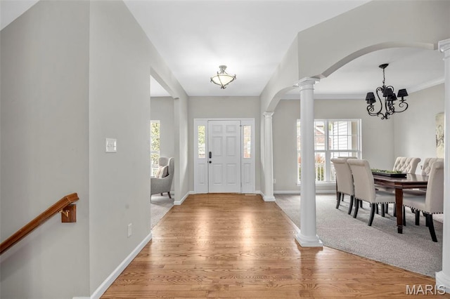 407 Forby Estates Dr, Eureka, MO 63025 - foyer with decorative columns, light wood-style flooring, a chandelier, arched walkways, and baseboards