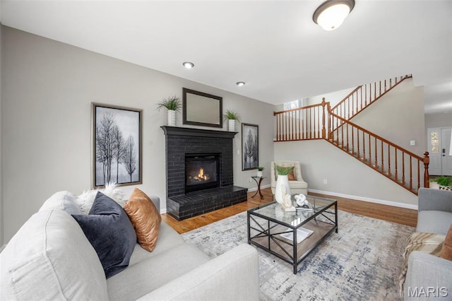 407 Forby Estates Dr, Eureka, MO 63025 - living area with stairway, wood finished floors, a fireplace, and baseboards