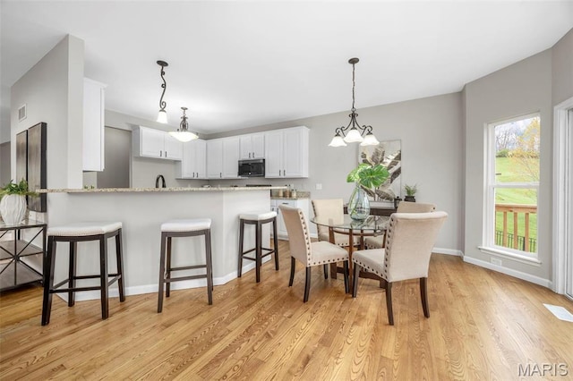 407 Forby Estates Dr, Eureka, MO 63025 - dining area featuring light wood-style floors, a chandelier, and baseboards