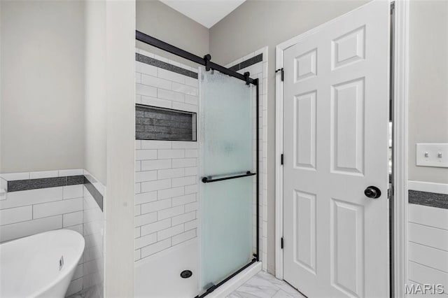 407 Forby Estates Dr, Eureka, MO 63025 - bathroom with a shower stall, a freestanding bath, marble look tiles, tile walls, and a wainscoted wall