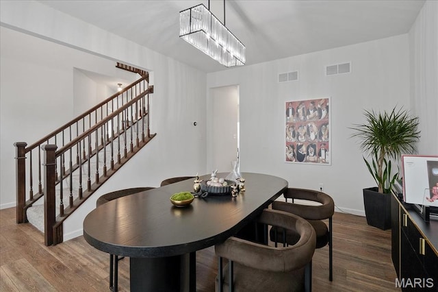 145 Pampano Ln, Saint Charles, MO 63301 - dining area featuring dark wood-style floors, stairs, baseboards, and a chandelier