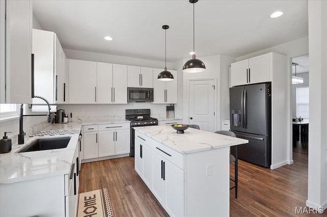 145 Pampano Ln, Saint Charles, MO 63301 - kitchen with black microwave, fridge with ice dispenser, stainless steel range with gas cooktop, a sink, and a kitchen island