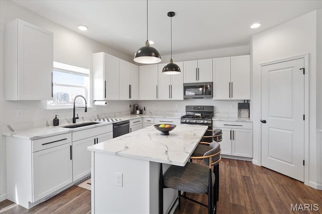 145 Pampano Ln, Saint Charles, MO 63301 - kitchen with appliances with stainless steel finishes, a sink, a breakfast bar area, a center island, and white cabinetry