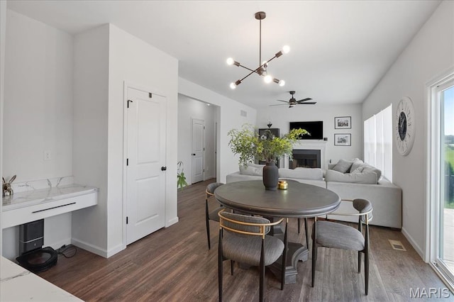 145 Pampano Ln, Saint Charles, MO 63301 - dining area with dark wood finished floors, a chandelier, a fireplace, and baseboards