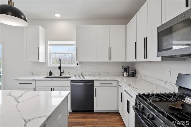 145 Pampano Ln, Saint Charles, MO 63301 - kitchen featuring stainless steel microwave, dishwashing machine, black range with gas cooktop, a sink, and white cabinetry
