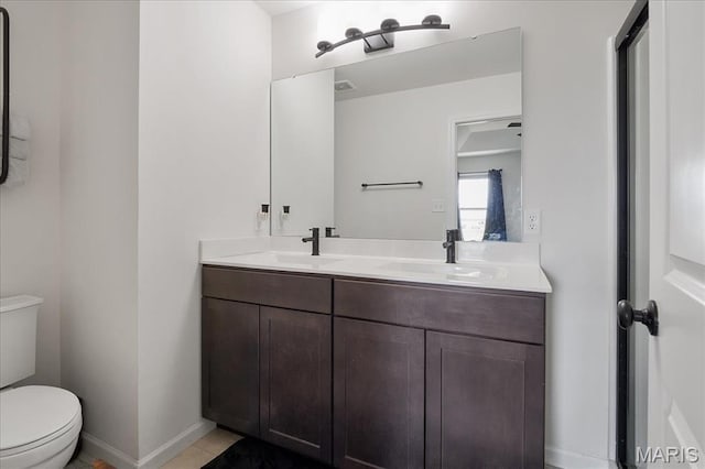 145 Pampano Ln, Saint Charles, MO 63301 - bathroom featuring toilet, double vanity, baseboards, and tile patterned flooring