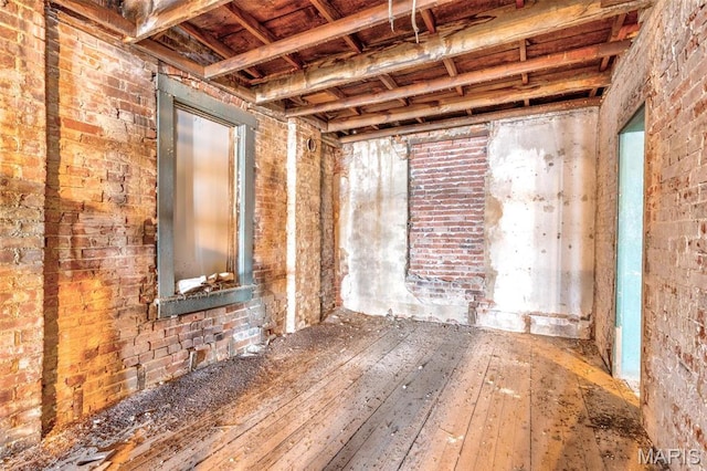 32 W School St, Bonne Terre, MO 63628 - spare room with hardwood / wood-style flooring and brick wall