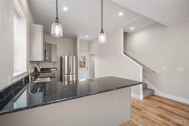 6800 Minnesota Ave, Saint Louis, MO 63111 - kitchen featuring stainless steel appliances, a peninsula, light wood-style floors, gray cabinets, and a sink
